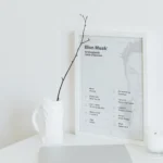 Elon Musk Success Poster paired with a laptop, notebooks, and creative workspace accessories on a desk in natural light.