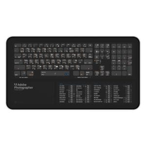 Top view of Adobe Photographer shortcut desk mat displaying essential Photoshop and Lightroom keyboard commands for photo editing professionals.