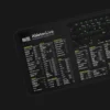 A music producer working with Ableton and referencing the shortcut mat during a real-time session