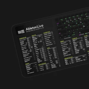 A music producer working with Ableton and referencing the shortcut mat during a real-time session