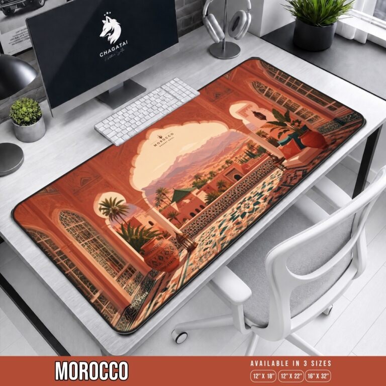 Morocco Desert Soul desk mat showing a tiled terrace beneath ornate arches, with palms, desert buildings, and distant mountains.